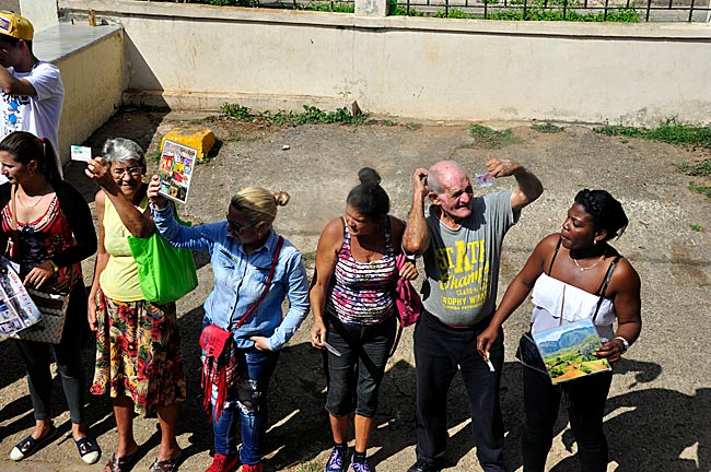 Ankunft des Viazul-Busses in Viñales: Vermieter von Privatpensionen halten den ankommenden Reisenden Bilder von ihren Casas Particulares zu den Busfenstern hoch, Region Pinar del Río, Kuba