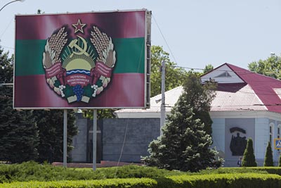 Transnistrien - Staatswappen von Transnistrien mit Hammer und Sichel steht auf einem großen Aufsteller in Tiraspol