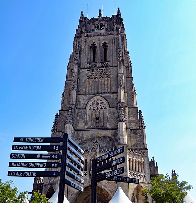 Belgien - Tongeren in Flandern - Dem Himmel so nah: Während die Menschen in alle Richtungen zu ihren Zielen laufen, wacht der mächtige Glockenturm der Liebfrauen-Basilika über der Stadt.