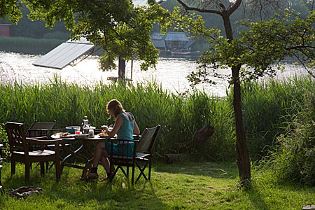 Dänemark - Frau isst an einem Tisch am See in Christiania in Kopenhagen, Foto: Robert B. Fishman, ecomedia