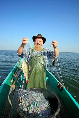 Deutschland - Mecklenburger Seenplatte - Fischer auf der Müritz in seinem Fischerboot