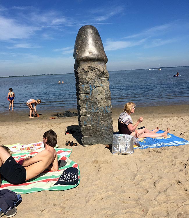 Granit-Phallus von Eckart Grenzer (1943-2017), 1984 an der Flutkante aufgestellt. Dangaster Kunstpfad, Jadebusen, Niedersachsen