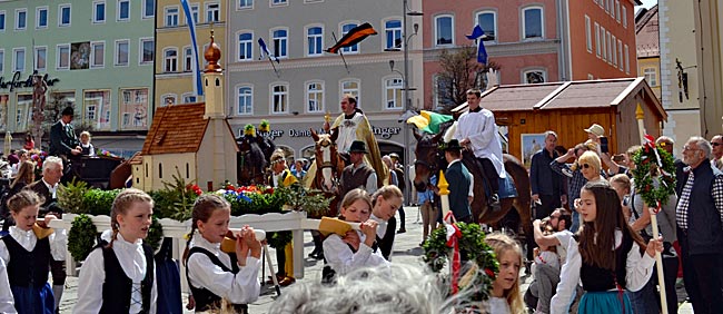 Georgi-Ritt in Traunstein - Tragende Rolle: Kinder ziehen mit einem Modell der Ettendorfer Kirche über den Stadtplatz, während der Pfarrer hoch zu Ross den Segen spendet