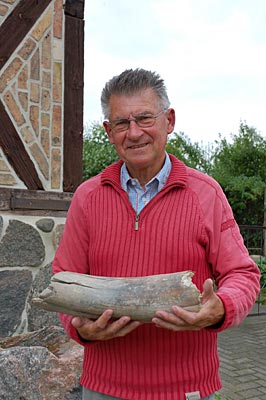 Mecklenburg-Vorpommern, Eiszeitroute im Geopark Mecklenburgische Eiszeitlandschaft, Geologe Klaus Granitzki mit einem Mammutstoßzahn in der Hand