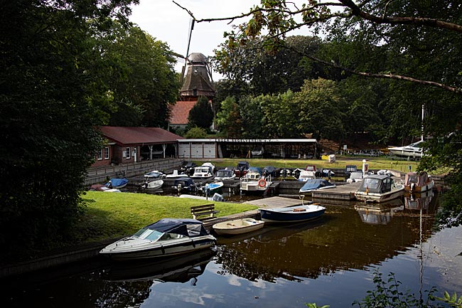 Emden in Ostfriesland - Emder Stadtgraben mit Sportbooten und der Mühle De Vrouw Johanna im Hintergrund