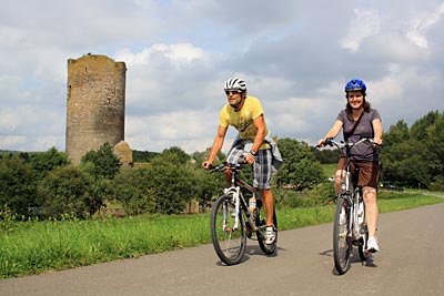 Hunsrück-Radweg - Ex-Rennradprofi Marcel Wüst (links) und eine E-Bike-Fahrerin auf dem Hunsrück-Radweg bei der Burgruine Baldenau