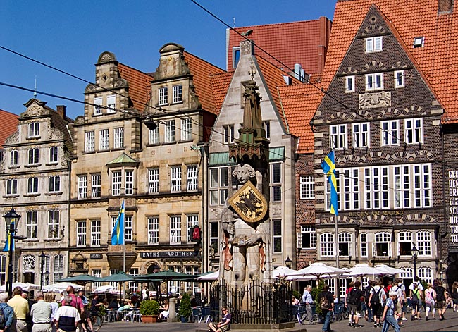 Seit 1404 steht der Roland aufrecht und stolz auf dem Marktplatz in der Innenstadt Bremens und repräsentiert die Freiheit der Hansestadt und ihrer Bürgerinnen und Bürger. Hinter dem Roland stehen alte Bürgerhäuser Blick über den Marktplatz in der Innenstadt mit dem Roland und den alten Bürgerhäusern im Hintergrund - Bremen sehenswert