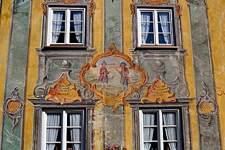 Oberbayern - Mittenwald - Bebilderte Bergpredigt: das Gleichnis vom Splitter im Auge des anderen und dem Balken im eigenen an einem Mittenwalder Wohnhaus