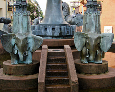 Zwei Elefanten tragen die Stadttürme der mittelalterlichen Befestigung Kaiserslauterns (Kaiserbrunnen)
