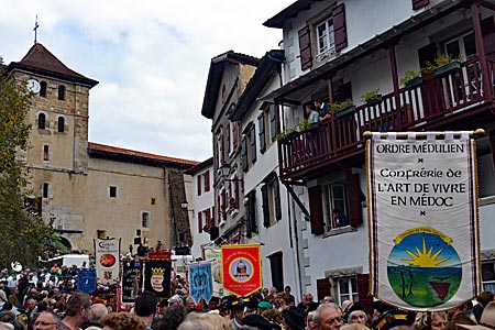 Frankreich - Baskenland - Folklore: Nach dem Gottesdienst in der Kirche von Espelette ziehen Bruderschaften durch den Ort. Auch dabei die „Bruderschaft der Lebenskunst im Médoc“ (vorne rechts) und die „Bruderschaft des baskischen Kuchens“ (hinten links)