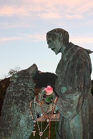 Italien - Wandern auf dem Franziskusweg Bronze Statue, die die Begegnung des hl. Franziskus mit dem Wolf zeigt