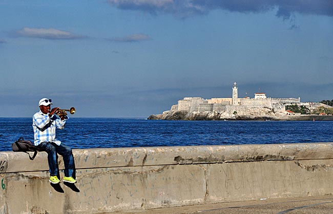 Trompeter am Malecón, im Hintergrund die Festung Castillo del Morro an der Einfahrt zur Bahía de la Habana, Kuba