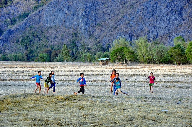 Laos - Reisfelder lassen sich auch als Fußballplätze verwenden