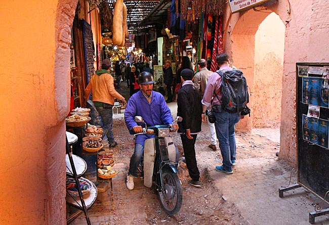 Marokko - Motorrollerfahrer in einem Souk in Marrakesch